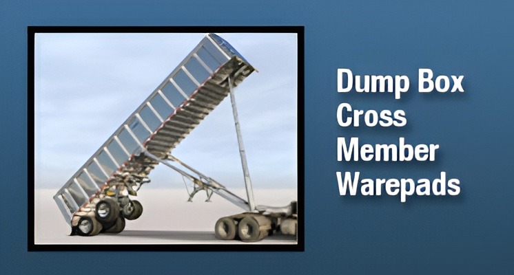 Tilted dump box attached to a truck, highlighting cross member and warepads, demonstrating loading or unloading functionality.
